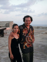 Load image into Gallery viewer, A couple posing together outdoors, with a scenic view and cloudy sky in the background.